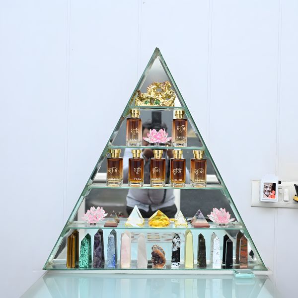 A triangular glass shelf of oils, crystal pyramids and crystal towers